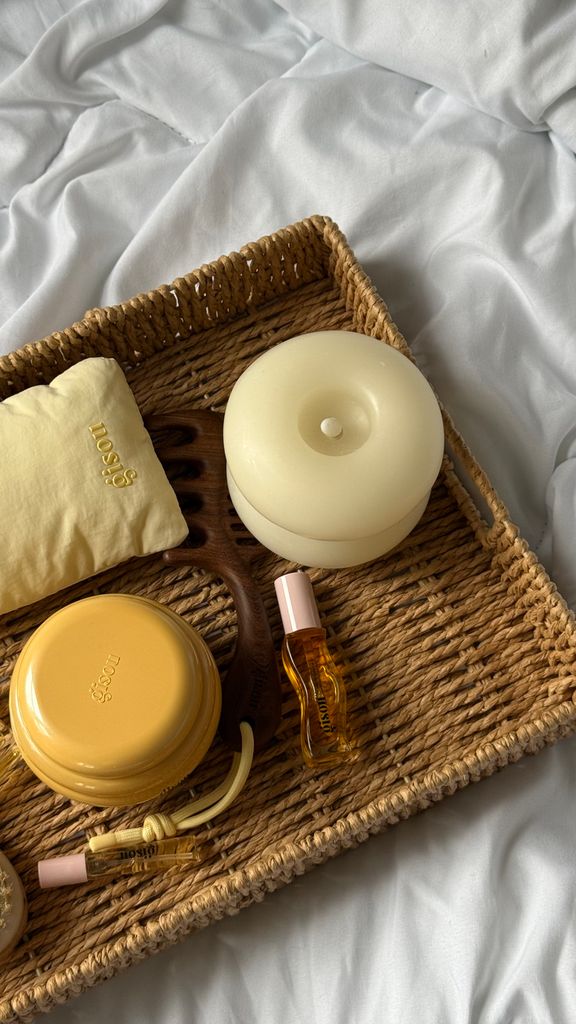 Serene arrangement of spa items on a wicker tray against a soothing backdrop.